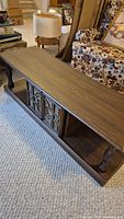 Front view of wooden retro coffee table with cupboard doors and open shelf below.