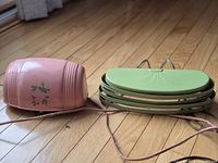 Pink and green vintage bed frame lights, not mounted, showing front designs and electrical cords.
