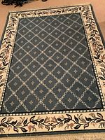 Full view of the 5 x 7 blue area rug showing the lattice and floral design with a floral border.