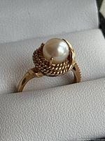 Three-quarter view highlighting rope-twist bezel and cultured pearl