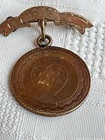 Front view of bar brooch and medallion showing engraved heart motif and border