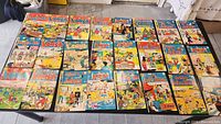 Top view showing all 24 Archie series comic books spread out on a surface.