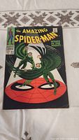 Photo of the front cover showing two winged green villains flying over a large Spider-Man logo, the title 'The Amazing Spider-Man' with 'Wings in the Night'.