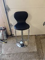 Full view of the black seat bar stool with chrome base, showing seat shape and design.