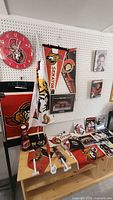 Overview of the Ottawa Senators memorabilia including clock, flags, framed photo, and signed beer bottle on table and pegboard