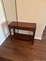 Full view of walnut entrance table with drawer and lower shelf, showing overall condition and design.