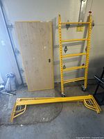 Two scaffold frames (one upright, one flat) and wooden plank