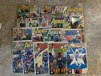 Overview photo of 20 Avengers comic books showing issues from 321 to 340 in three rows on carpet. Covers visible showing classic comic art and titles.