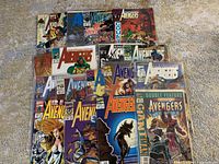 Photo shows full spread of Avengers comic covers in the lot, arranged fanned out. Colorful character artwork with issue numbers visible.
