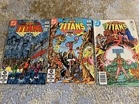 Photo showing the three Teen Titans comic books laid out side by side: Issue 26, Issue 28, and Issue 30.