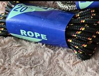 Close-up photo of black braided rope with red, yellow, and white flecks, wrapped with a blue label indicating '20 ft. rope'.