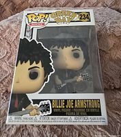 Photo of Billie Joe Armstrong Green Day Funko Pop figure in original box showing front view of packaging and vinyl figure inside.