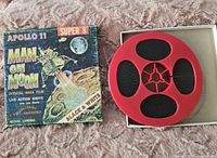 Super 8 film reel in red plastic reel with original box showing Apollo 11 Man on the Moon artwork.
