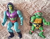 Photo of Skeletor and Raphael action figures placed side by side on a soft textured surface