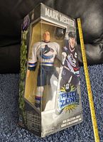 Front side of the figure in its original clear window box showing the figure dressed in the Vancouver Canucks uniform with Mark Messier name on top.