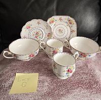 Photo of Royal Albert Petit Point china set with two small plates, two small cups, one handled cup, and one bowl, showing overall design and condition.