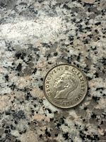 Front side of the 1940 Canadian 50 cents silver coin showing the profile of King George VI and inscriptions around the edge.