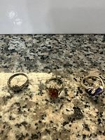 Three silver rings posed on a speckled granite surface showing overall style and design.