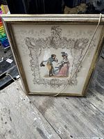 Front view of the large vintage framed print showing a romantic scene of a man tipping his hat to a woman, surrounded by an ornate carved decorative border.