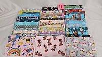 Top view of multiple folded cotton fabric pieces displaying colorful cartoon characters, polka dots, and various patterns.