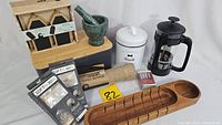 Complete set showing chalk tags in wooden box, green marble mortar and pestle, white ceramic biscuit jar, black French press, burlap table runner, LED micro light packages, and wooden bread tray