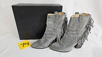 Gray suede ankle boots with fringe detail shown with Joe's branded black box.