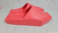 Side profile of coral Nike Hex slides showing thick geometric sole and closed-toe design.