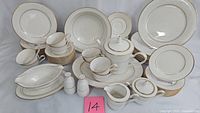 Complete 34-piece Noritake Tulane dinnerware set displayed including plates, cups, saucers, teapot, creamer, sugar bowl, gravy boat, and salt and pepper shakers.