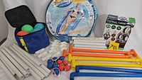 Full lot view showing bocce balls, ladderball poles, Soccer Football Target Game box and SwimWays Spring Float in packaging