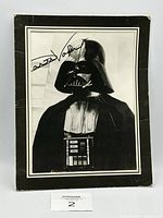 Full black and white photo of Darth Vader with visible signature in black marker, showing edges and wear.