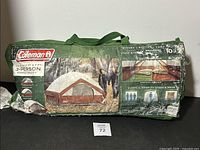 Photo of the Coleman tent in green carrying bag with printed image and specifications.
