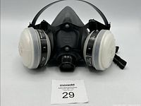 Front and full view of Honeywell 5500 Series half mask respirator in black with white circular filters attached on each side and adjustable head straps.