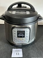 Front view of Instant Pot Duo Mini showing digital control panel and plastic lid handle with ding.