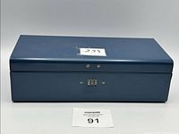 Front view of rectangular blue metal lock box with combination lock on front center.