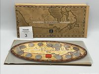 Overall view of 1999 Millennium Canada coin set in original packaging with oval coin board on display.