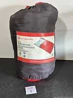 Photo of the sleeping bag in its compact storage sack showing brand and product label