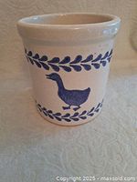 Side view of ceramic crock pot showing the blue goose silhouette and blue leaf border design.