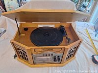 Opened wooden retro Curtis stereo system showing record turntable and tone arm.
