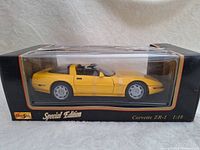 Side view of the yellow Maisto Corvette ZR-1 model in its original box with clear plastic window, showing detailed side profile of car.
