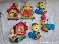 Photo showing six vintage chalkware pieces: bird houses, birds in hats, and children figures with painted colorful details.
