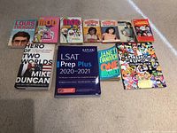 Photo of 10 books arranged on carpeted floor showing covers clearly.