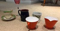 Photo showing all six items on carpet including mugs, creamer, wine glass, tea cup and saucer