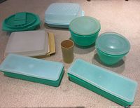 Top view of all Tupperware pieces laid on carpet showing bowls, containers, lids, and cup.
