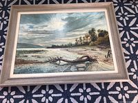 Overall view of framed landscape painting on patterned rug