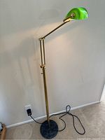 Full view of the brass banker style floor lamp showing its height and base.