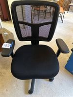 Front view of the black ergonomic mesh office chair showing the full seat, mesh backrest, and armrests.