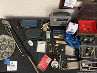 Wide view of the collection showing various men's accessories including a fly swatter, shoehorn, tools, flask, sunglasses, and cuff links.