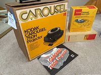 Image showing Kodak Carousel 750H projector original box, manual, and Kodak Carousel stack loader box stacked on top.