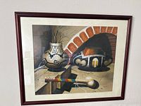 Full view of the framed artwork showing two pottery pieces and tools against a brick arch background.