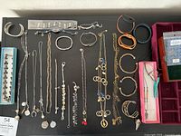 Overview of assorted bracelets, necklaces and accessories on black background